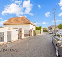 A family house on Kúpeľná Street in Dunajská Streda surrounded by cars and fencing.