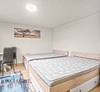 A bedroom in a family house with two beds, a wardrobe, and a wooden decor floor.