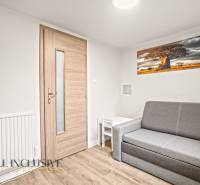 Living room in a family house with a sofa, table, and wooden decor flooring.