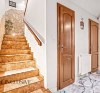 A staircase with a stone wall and tiles in a family house.