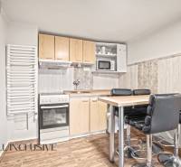 A kitchen in a family house with a countertop, chairs, and a floor with a wooden decor.