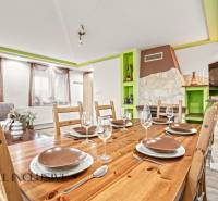 Dining room in a family house with a wooden table, glasses, and a decorative fireplace.