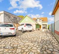 A family house on Kúpeľná Street in Dunajská Streda with a stone courtyard and parked cars.