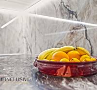 A fruit bowl on a stone kitchen countertop in a family house.