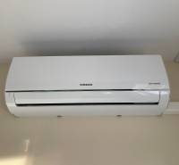 The air conditioning on the wall is part of the equipment of a studio apartment.