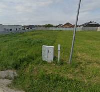 Green building plot bordered by a fence in the Čaňa area suitable for residential use.