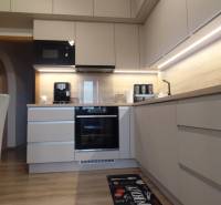 A kitchen in a 3-room apartment with a wooden decor floor and built-in appliances.