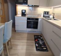 A kitchen with a wood-patterned floor in a 3-room apartment, featuring modern equipment and decor.