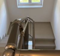 A staircase with a metal railing and a window in a 3-room apartment.