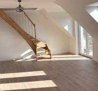 Attic space in a 3-room apartment with a wooden decor floor and a staircase.