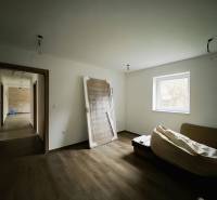 A room in a family house with a wooden decor floor and simple furnishings.
