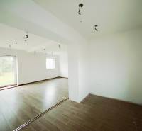 Interior of a family house with a wooden decor floor and large windows to the garden.