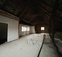 Attic space of a family house with exposed roof structure and white walls.