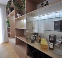 Interior of a family house with a wardrobe, glass shelves, and a floor with a wooden decor.
