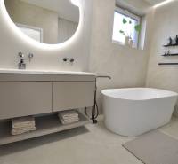 A bathroom in a family house with a freestanding bathtub and a floor with a delicate pattern.