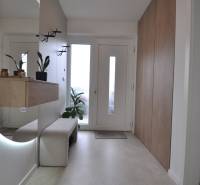 Entrance hall in a family house with a large mirror and storage spaces.