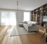 Living room of a family house with a bookshelf, sofa, and wooden decor flooring.