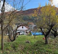 A family house in Stará Kremnička with fruit trees on a sloped plot.