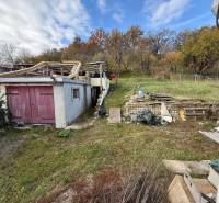 A family house in Stará Kremnička with an unmaintained garden, an old garage, and a wooden structure.