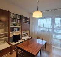 Dining area with a bookshelf and a glass cabinet in a 3-room apartment.