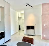 Interior of a 1-room apartment with a kitchen unit, dining table, and light-colored walls.