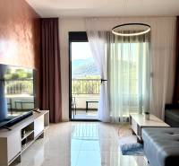 Living room in a studio apartment with marble flooring and a mountain view.