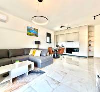 Interior of a 1-room apartment with a sofa, kitchenette, and dining table.