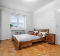 A bedroom in a 3-room apartment with wooden furniture and a wooden decor floor.