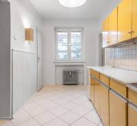 A kitchen in a 3-room apartment with a colorful kitchen unit, a radiator, and tiled flooring.