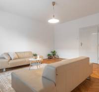 Living room in a 3-room apartment with sofas and wooden decor flooring.
