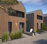 A family house in Turecká with wooden cladding, people relaxing on a bench.