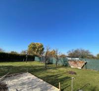 A garden by the cottage in Nova Osada in Komárno with a lawn and a fireplace.