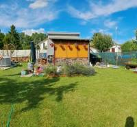 A garden at the cottage in Nova Osada in Komárno with a blue sky and a manicured lawn.