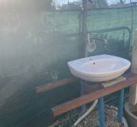 A sink at the cottage in Nova Osada in Komárno, outdoors with protective mesh.