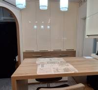 A kitchen in a 3-room apartment with white cabinets and a wooden table, flooring with a wooden decor.