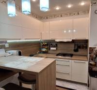 Compact kitchen in a 3-room apartment with white cabinets and wooden decor.