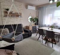 Living room in a 3-room apartment with a sofa, swing, and dining table.