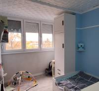Children's room with blue walls, white cabinets, and a children's play mat.