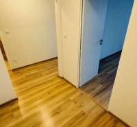 An interior with white walls and a wooden decor floor in a studio apartment.