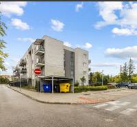 Apartment building on Mahulanka Street in Pezinok with a parking lot and containers.