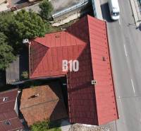 The roof of a building in Belá and a road with cars from a bird's-eye view.