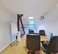 Offices with wooden decor flooring, desk, chairs, flipchart, water on the table.