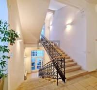A bright staircase with decorative railings leading to offices.