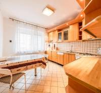 A kitchen in a 4-room apartment with light seating and wooden decor equipment.