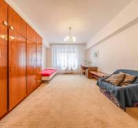 A room in a 4-room apartment with a large wardrobe, a sofa, and a single bed.