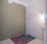 A room under construction in a 2-room apartment with wiring on the floor.