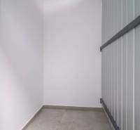 Storage space with tiled flooring in a 2-room apartment with smooth white walls.