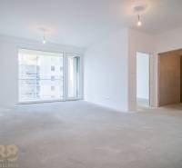Spacious living area in a 2-room apartment with large windows without flooring with wooden decor.