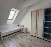 Children's room with a skylight, bed, and wardrobe in a 4-room apartment.
