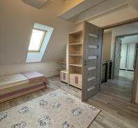Children's room in a 4-room apartment with a wooden decor floor and a decorative carpet.